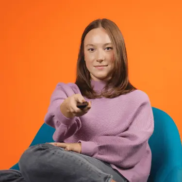 Girl holding a tv remote looking at tv